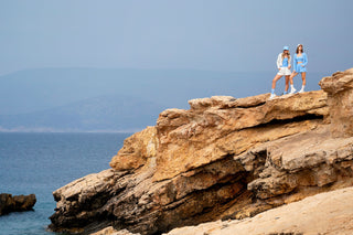 Zwei Frauen in Kersy Sommerkleidung auf einer Klippe am Meer stehend